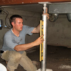 A contractor in Sunnyvale installing a crawl space jack post.