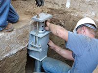 Foundation repair contractors installing the foundation bracket in Fresno.