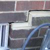A closeup of a failed tuckpointing job where the brick cracked on a Merced home.