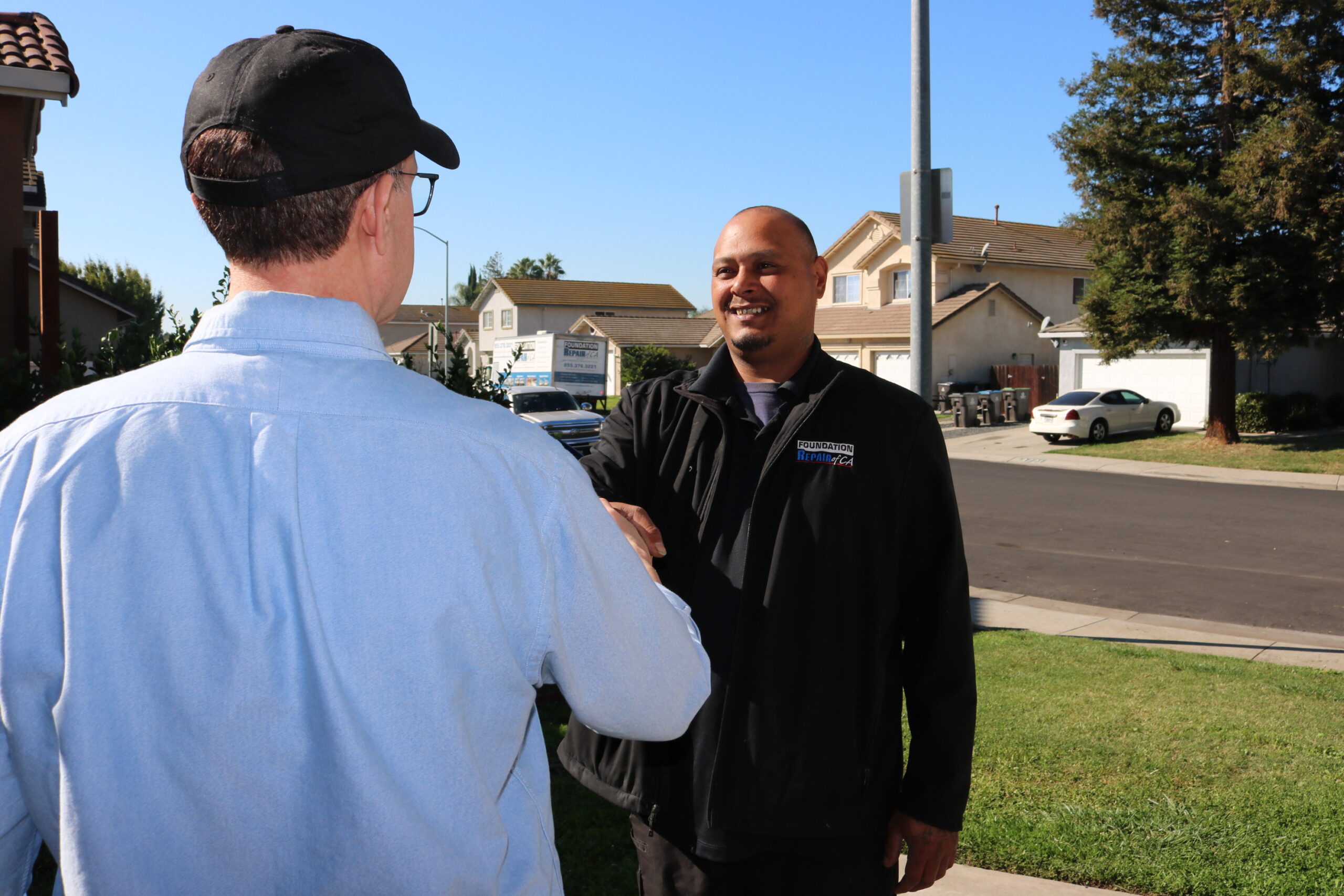 Foundation repair specialist shaking hands with homeowner